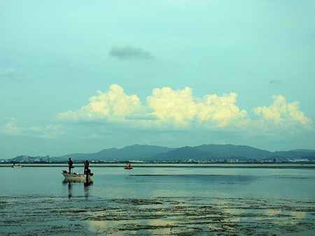 夏雲と釣り舟映す琵琶湖の面 